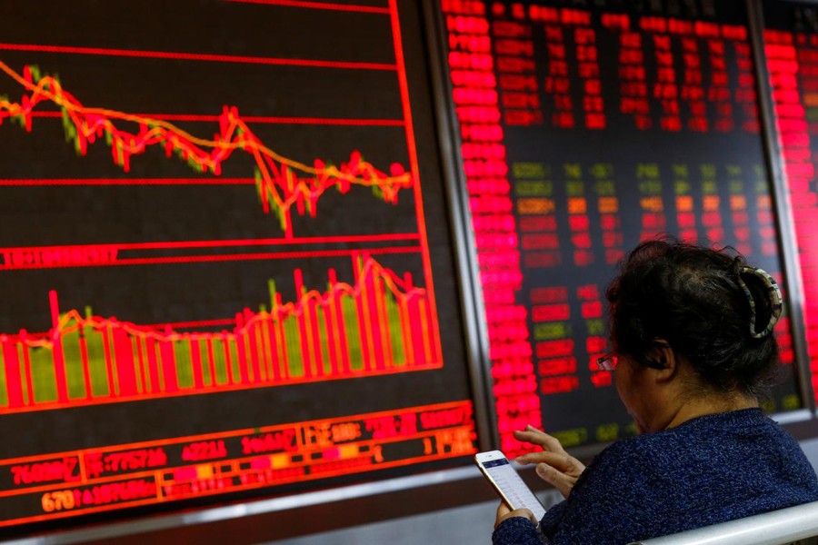 An investor sits in front of a board showing stock information at a brokerage office in Beijing, China, December 7, 2018. Reuters