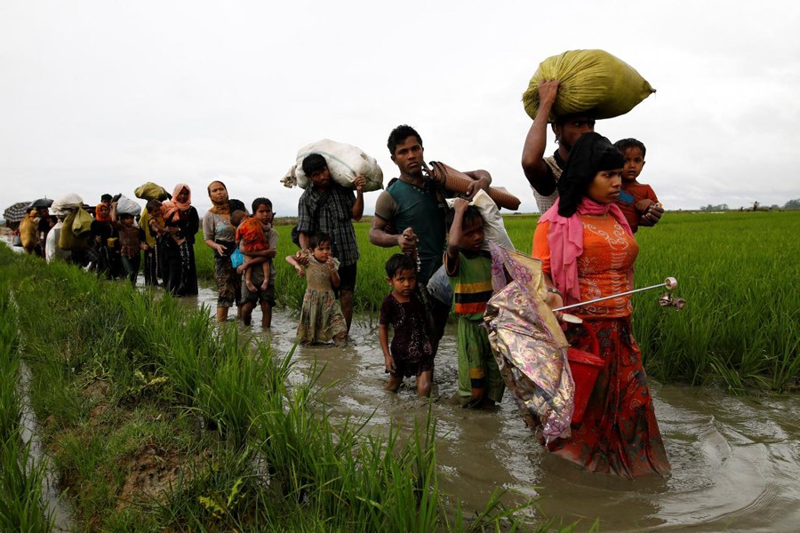 A group of Rohingya refugee people walk in the water after crossing the Bangladesh-Myanmar border in Teknaf, Bangladesh, September 1, 2017. Reuters/Files