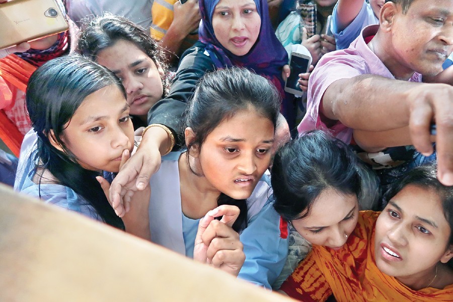 Students check their marks on the result board. FE file photo