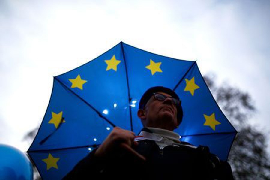 An anti-Brexit demonstrator stands under an EU flag umbrella outside the Houses of Parliament in London, Britain, December 10, 2018. Reuters/Files