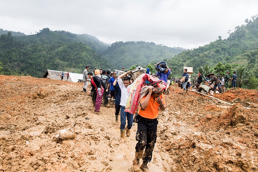 Residents carry their belongings following landslides at Cisolok district in Sukabumi, West Java province, Indonesia on Tuesday — Reuters photo