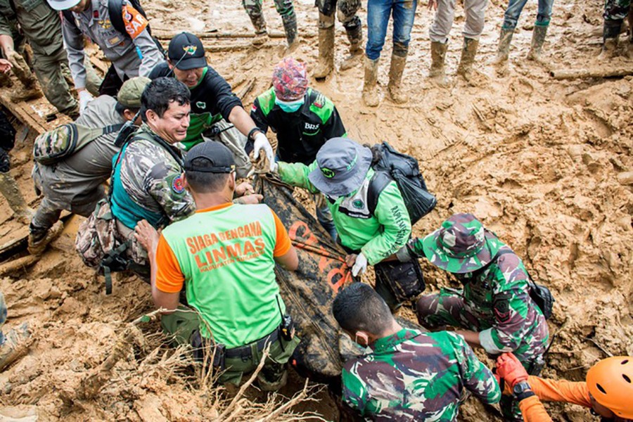 Rescue workers carry a body bag containing remains of victims following a landslide at Cisolok district in Sukabumi, West Java province, Indonesia, January 1, 2019. Reuters