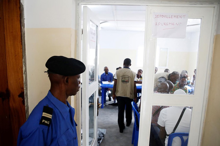 A Congolese policeman guards a room where officials of Congo's Independent National Electoral Commission (CENI) count presidential elections ballots at a tallying centre in Kinshasa, Democratic Republic of Congo, January 4, 2019. Reuters