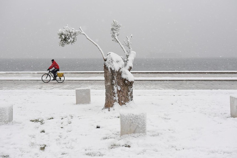 A man rides his bike during snowfall at the seaside promenade of Thessaloniki, Greece on Friday — Reuters photo