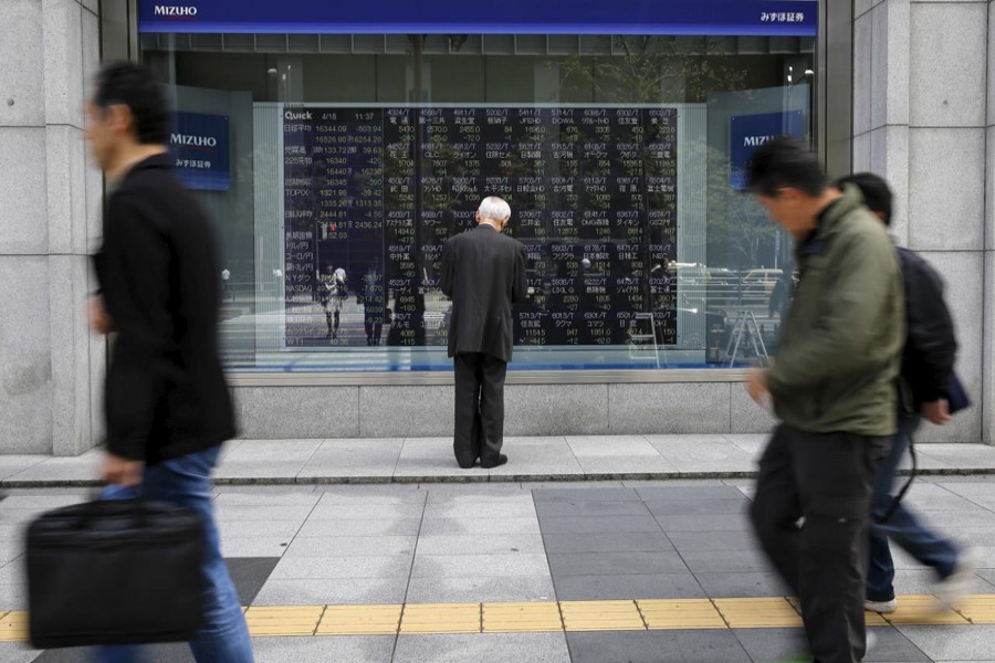 A man looks at a stock quotation board outside a brokerage in Tokyo, Japan, April 18, 2016. Reuters/Files