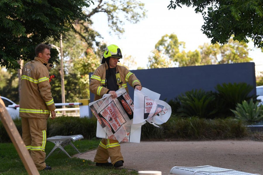 A fire fighter is seen carrying hazardous material bags into the South Korean consulate in Melbourne, Australia, January 9, 2019 - AAP Image/James Ross via REUTERS