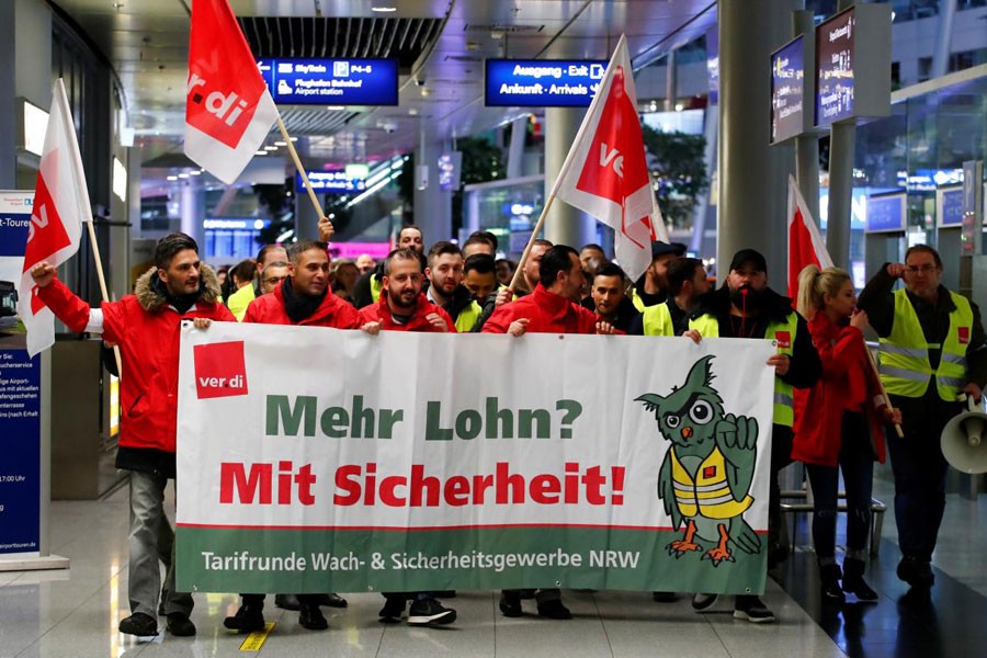 Employees of Duesseldorf Airport march through the main hall during a strike by German union Verdi, which called on security staff at Duesseldorf, Cologne and Stuttgart airports to put pressure on management in wage talks, in Duesseldorf, Germany January 10, 2019 - REUTERS/Wolfgang Rattay