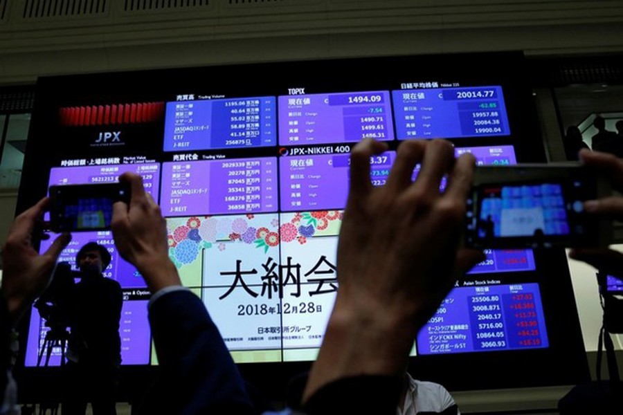 Attendees take pictures of a stock quotation board after a ceremony marking the end of trading in 2018 at the Tokyo Stock Exchange (TSE) in Tokyo, Japan, December 28, 2018. Reuters/Files
