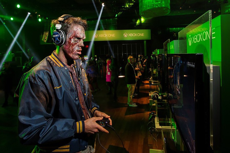 A man dressed as a zombie plays video games on an Xbox One console during a midnight launch event in New York, November 21, 2013. Reuters/File photo