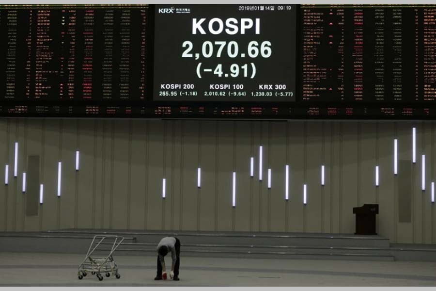 A worker checks the floor near the screen showing the Korea Composite Stock Price Index (KOSPI) at the Korea Exchange in Seoul, South Korea, Monday, Jan. 14, 2019 (AP Photo)