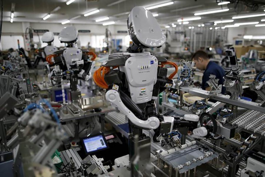 Humanoid robots work side by side with employees in the assembly line at a factory of Glory Ltd, a manufacturer of automatic change dispensers, in Kazo, north of Tokyo, Japan, July 1, 2015. Reuters/File