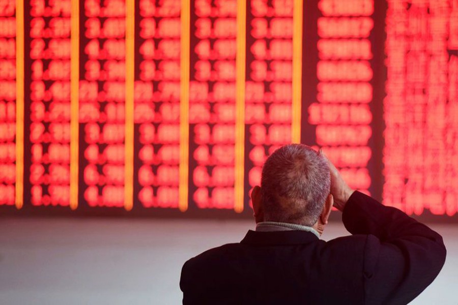 A man sits in front of an electronic board showing stock information at a brokerage house in Hangzhou, Zhejiang province, China, December 3, 2018. Reuters/Files