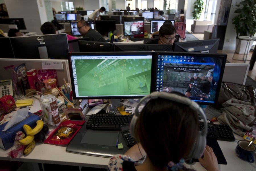 FILE PHOTO: An employee watches a computer screen displaying the video game "Glorious Mission Online" at the game developer's office in Shanghai August 2, 2013 - REUTERS/Aly Song
