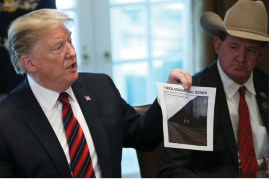 US President Donald Trump shows a photo of a "typical" border wall design during a "roundtable discussion on border security and safe communities" with state, local, and community leaders in the Cabinet Room of the White House in Washington, US on January 11, 2019.           —Reuters