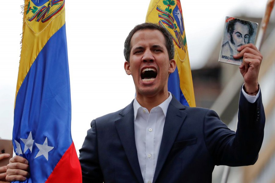 Juan Guaido, President of Venezuela's National Assembly, holds a copy of Venezuelan constitution during a rally against Venezuelan President Nicolas Maduro's government and to commemorate the 61st anniversary of the end of the dictatorship of Marcos Perez Jimenez in Caracas, Venezuela January 23, 2019. Reuters