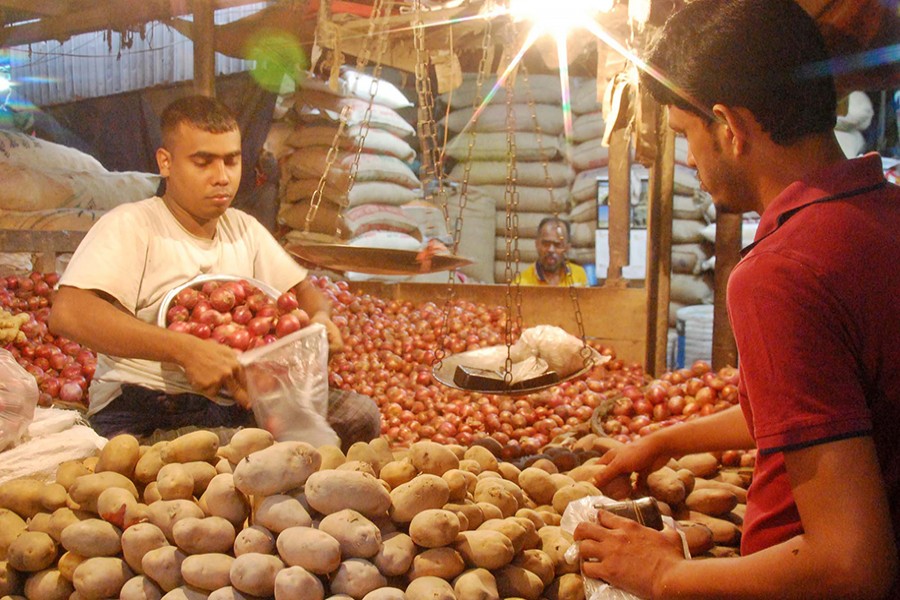 A vegetable vendor seen selling potatoes to a customer at Kaptan Bazar in Dhaka's Gulistan in this undated Focus Bangla photo