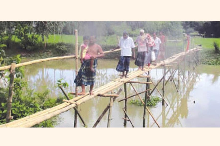 People using Bamboo Bridge over Iramaty Khal under Dupchanchia upazila of Bogura district — FE Photo