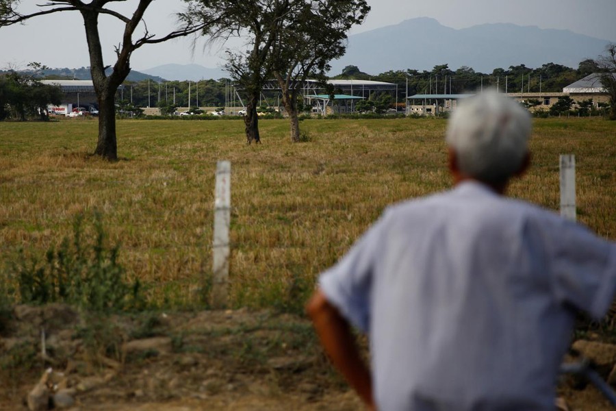 A man looks on after trucks arrived at a warehouse, where international humanitarian aid for Venezuela will be stored according to authorities, near the Tienditas cross-border bridge between Colombia and Venezuela, in Cucuta, Colombia, February 7, 2019. Reuters