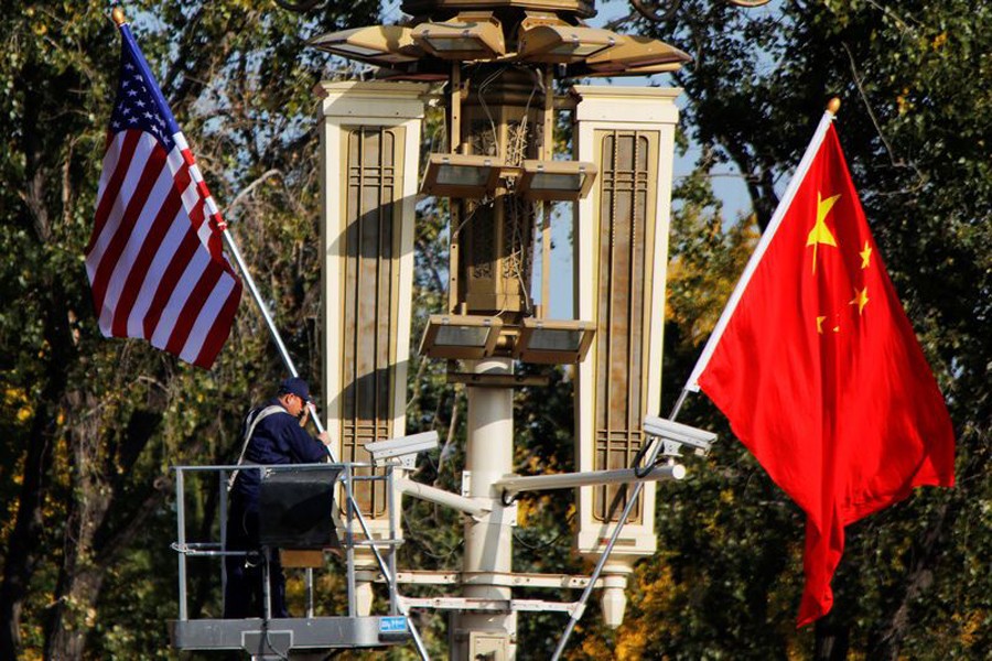 A worker places US and China flags near the Forbidden City ahead of a visit by US President Donald Trump to Beijing, in Beijing, China November 8, 2017. Reuters/Files