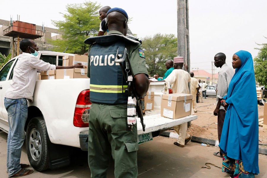 A police member oversees Ad-hoc staff loading boxes onto a truck during the distribution of election materials at the INEC office in Yola, in Adamawa State, Nigeria February 15, 2019 - REUTERS/Nyancho NwaNri
