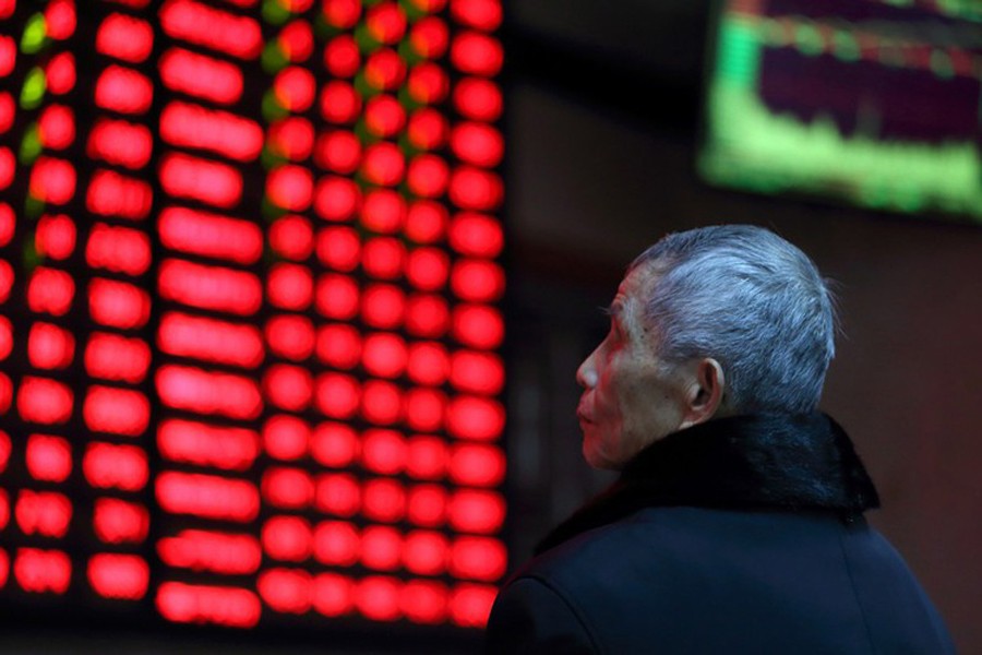 A man looks on in front of an electronic board showing stock information at a brokerage house in Nanjing, Jiangsu province, China, February 13, 2019. Reuters