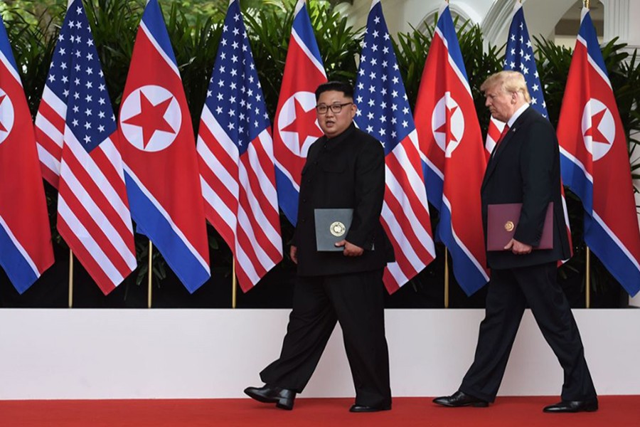 US President Donald Trump (R) and North Korea's leader Kim Jong Un walk during their summit at the Capella Hotel on Sentosa island in Singapore on June 12, 2018 — Reuters/File