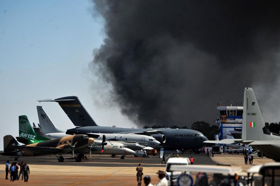 Fire fighters extinguishing smouldering cars after a fire broke out in a parking lot during the Aero India show at the Yelahanka Air Force Station in Bengaluru of India. -Reuters photo