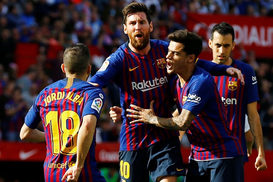 Barcelona's Lionel Messi celebrates with teammates after scoring his first of the treble, from a sublime volley, against Sevilla — Reuters photo