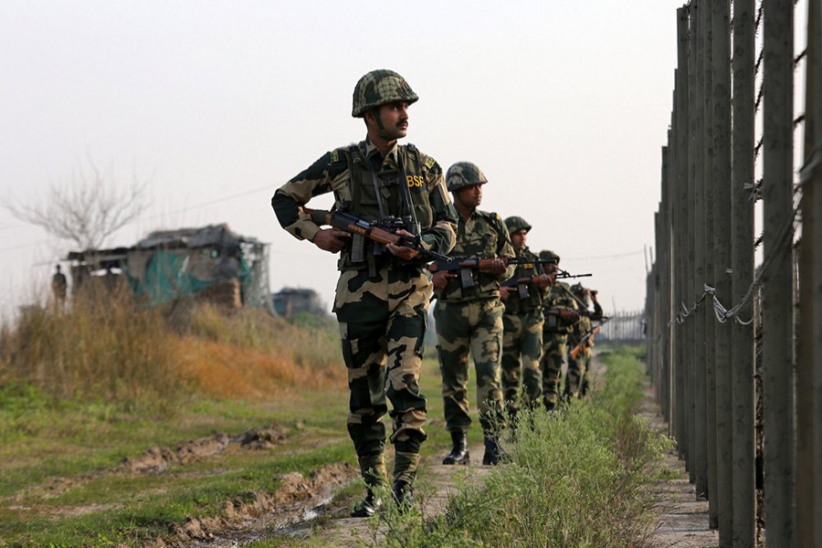 India's Border Security Force (BSF) soldiers patrol along the fenced border with Pakistan in Ranbir Singh Pura sector near Jammu on Tuesday — Reuters photo