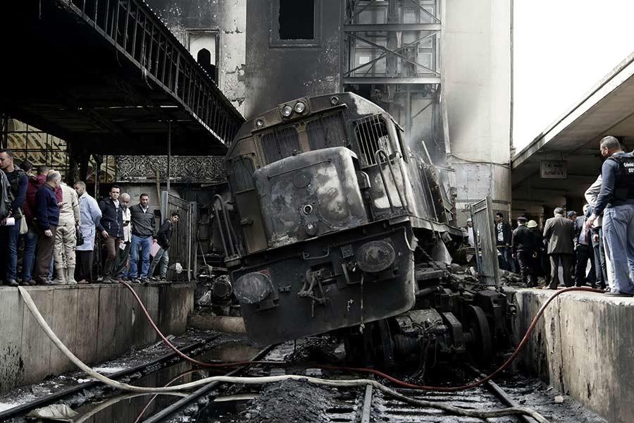 People looking at a damaged train inside Ramsis train station in Cairo of Egypt on Wednesday. -AP Photo