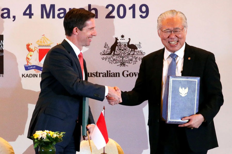 Australian Trade Minister Simon Birmingham, left, and Indonesian counterpart Enggartiasto Lukita shake hands after signing the economic partnership agreement in Jakarta on March 4 - Reuters