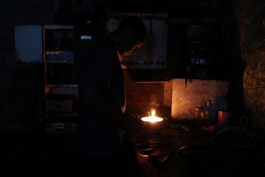 A local works inside a mechanical workshop during a blackout in Caracas, Venezuela, March 8, 2019 - REUTERS/Ivan Alvarado