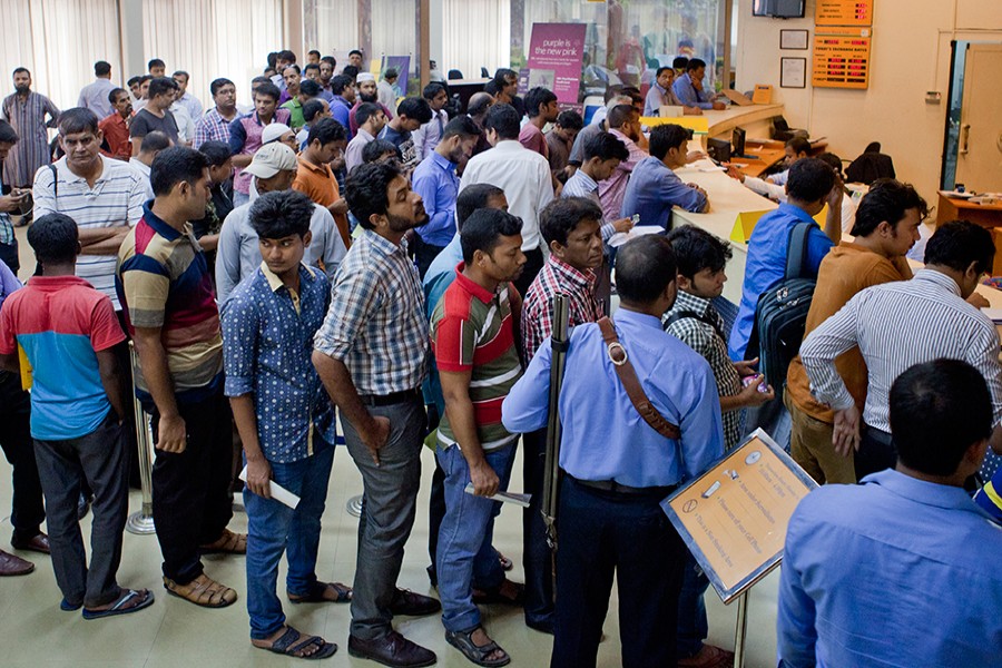 People queue up inside a bank in Dhaka city as they wait to deposit or withdraw cash — FE file photo