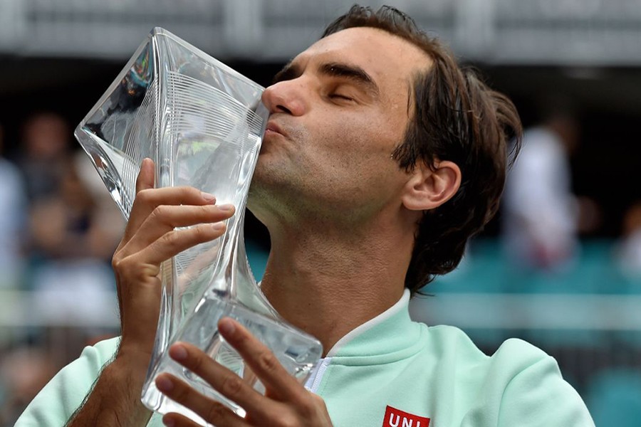 Roger Federer of Switzerland celebrates with the trophy after defeating John Isner of the United States (not pictured) during the men’s finals at the Miami Open — USA TODAY Sports photo via Reuters