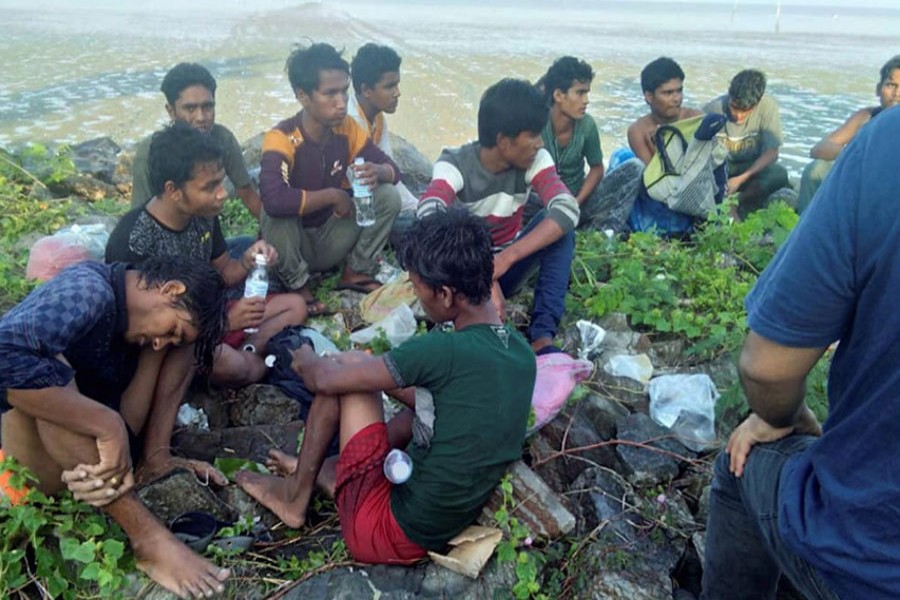 Dozens of people, believed to be Rohingya Muslims from Myanmar who were dropped off from a boat, are pictured on a beach near Sungai Belati, Perlis, Malaysia in this undated handout photo released April 8, 2019. Royal Malaysian Police/Handout via Reuters