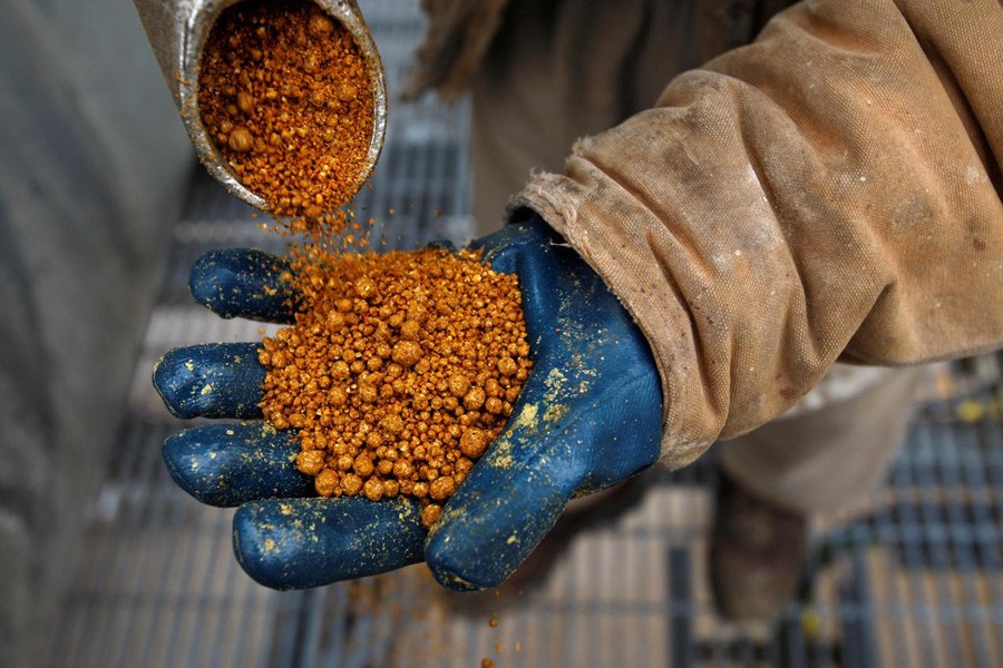 A process operator holding a handful of dried distillers grains, a protein animal feed that can be fed to livestock, at the GreenField Ethanol plant in Chatham, Canada	— Reuters