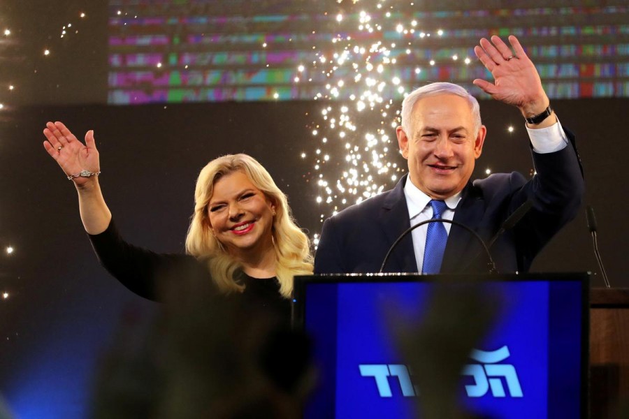 Israeli Prime Minister Benjamin Netanyahu and his wife Sara wave as Netanyahu speaks following the announcement of exit polls in Israel's parliamentary election at the party headquarters in Tel Aviv, Israel April 10, 2019 - REUTERS/Ammar Awad