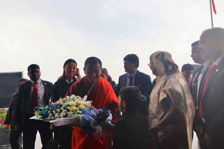 Bhutanese Prime Minister Lotay Tshering receives a bouquet from a child upon his arrival at Hazrat Shajalal International Airport on Friday morning. Photo courtesy: PMO Bhutan via Facebook