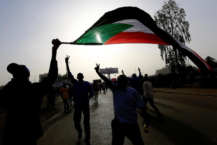 Sudanese demonstrators wave their national flag as they arrive for a protest rally demanding Sudanese President Omar Al-Bashir to step down outside the Defence Ministry in Khartoum, Sudan April 11, 2019 - REUTERS/Stringer