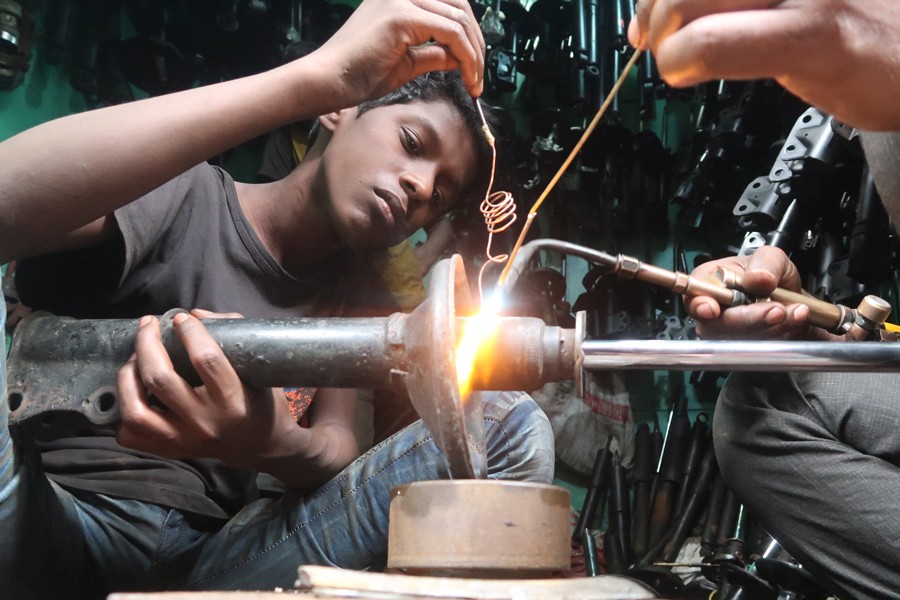 A boy  working at a light engineering workshop in Old Dhaka recently  	— FE photo by Shafiqul Alam
