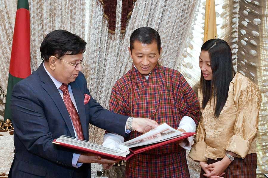 Foreign Minister Dr AK Abdul Momen handing over a photo album to Bhutanese Prime Minister Dr Lotay Tshering at Hazrat Shahjalal International Airport in Dhaka on Monday. -PID Photo