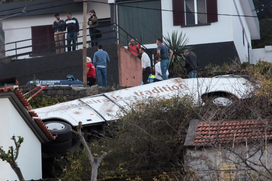 People stand next to the wreckage of a bus after an accident in Canico, in the Portuguese Island of Madeira, April 17, 2019 - REUTERS/Duarte Sa