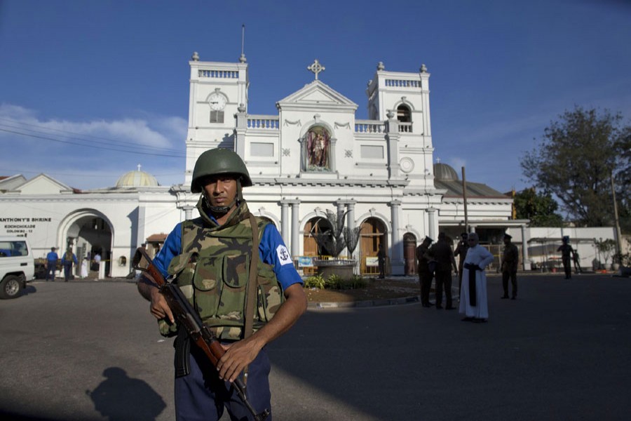 Sri Lankan air force officers and clergy stand outside St Anthony's shrine, a day after a blast in Colombo, Sri Lanka, Monday, April 22, 2019. Easter Sunday bombings of churches, luxury hotels and other sites was Sri Lanka's deadliest violence since a devastating civil war in the South Asian island nation ended a decade ago. AP