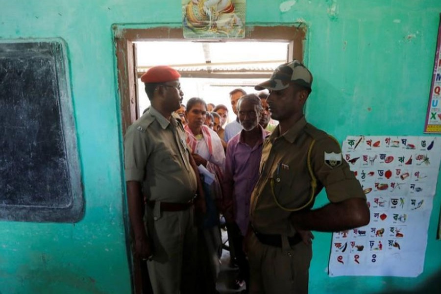 Policemen stand guard as voters wait for their turn to cast their vote at a polling station during the first phase of general election in Majuli, a large river island in the Brahmaputra river, Assam, April 11, 2019. Reuters/File Photo