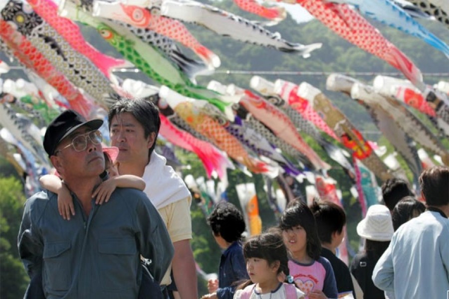 Holidaymakers view thousands of carp streamers hanging on the bank of the Sagami river in Sagamihara, southwest of Tokyo, May 3, 2005. Reuters/Files