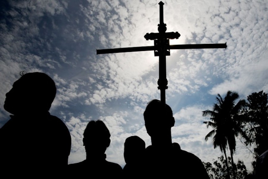 A man holds a cross during a mass burial of victims, two days after a string of suicide bomb attacks on churches and luxury hotels across the island on Easter Sunday, at a cemetery near St Sebastian Church in Negombo, Sri Lanka, April 23, 2019. Reuters