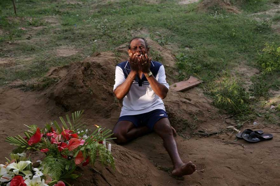 A man mourns at a grave of a victim, two days after a string of suicide bomb attacks on churches and luxury hotels across the island on Easter Sunday, at Sellakanda Catholic cemetery in Negombo, Sri Lanka April 23, 2019. - Reuters