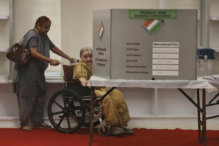 An elderly Indian citizen on a wheel chair casts her vote at a polling center during the fourth phase of general elections in Mumbai, India on April 29, 2019 — AP photo