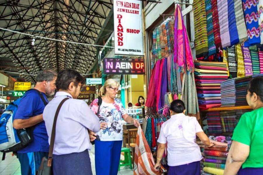 Tourists browse at shops in Bogyoke Market in Yangon. (The Myanmar Times Photo)