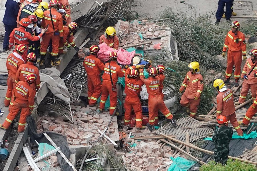 Firefighters carry a casualty on a stretcher at the site where a building collapsed, in Shanghai, China on May 16, 2019 — Reuters photo